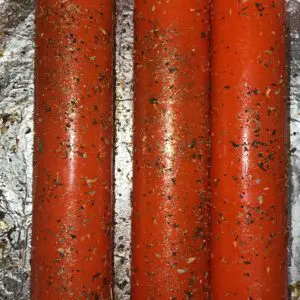 Three red candles are on a foil wrapper.