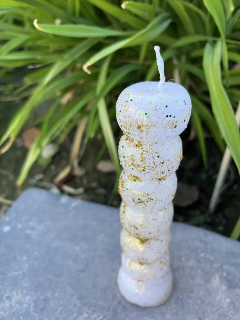 A candle that is sitting on the ground. A candle that is sitting on the ground.