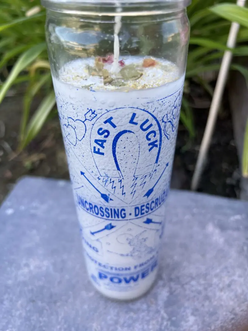 A candle in a glass with the words " fast luck " on it. A candle in a glass with the words " fast luck " on it.