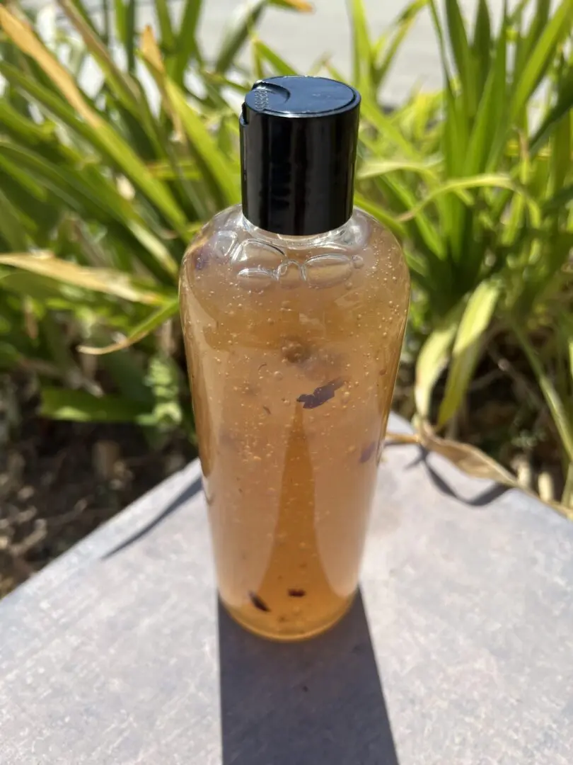 A bottle of liquid sitting on top of a table. A bottle of liquid sitting on top of a table.