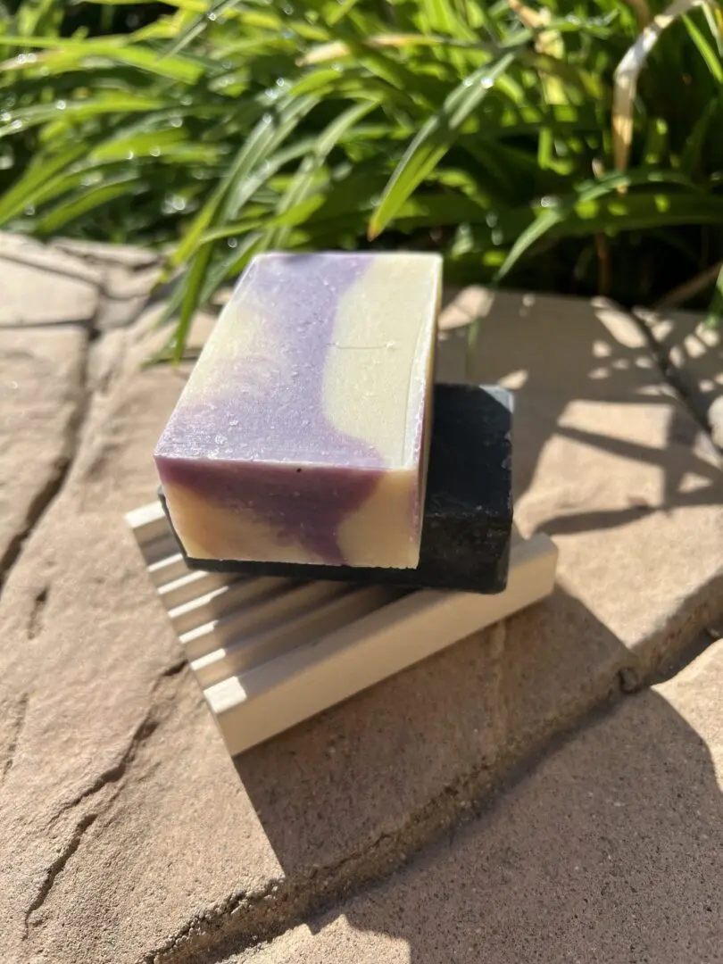A soap sitting on top of a wooden holder. A soap sitting on top of a wooden holder.