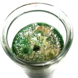 A glass of water with green liquid inside.