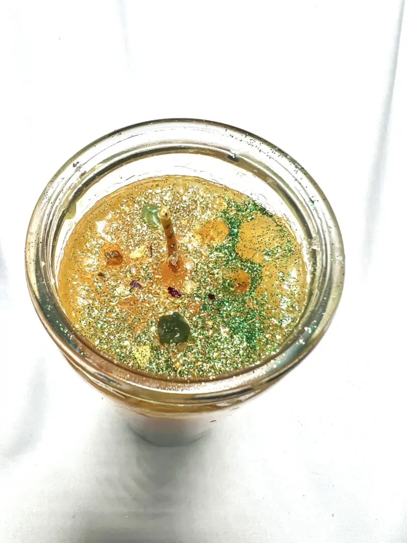 A glass of liquid with some green stuff in it A glass of liquid with some green stuff in it