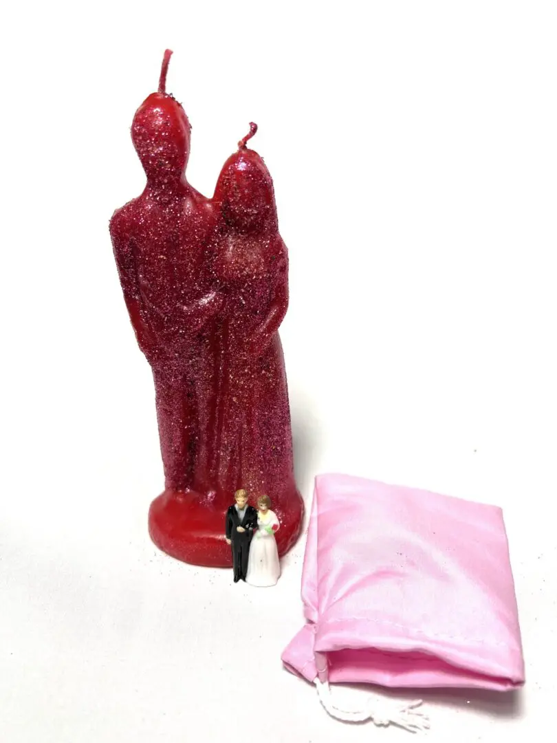 A candle that is sitting next to a pink pillow. A candle that is sitting next to a pink pillow.