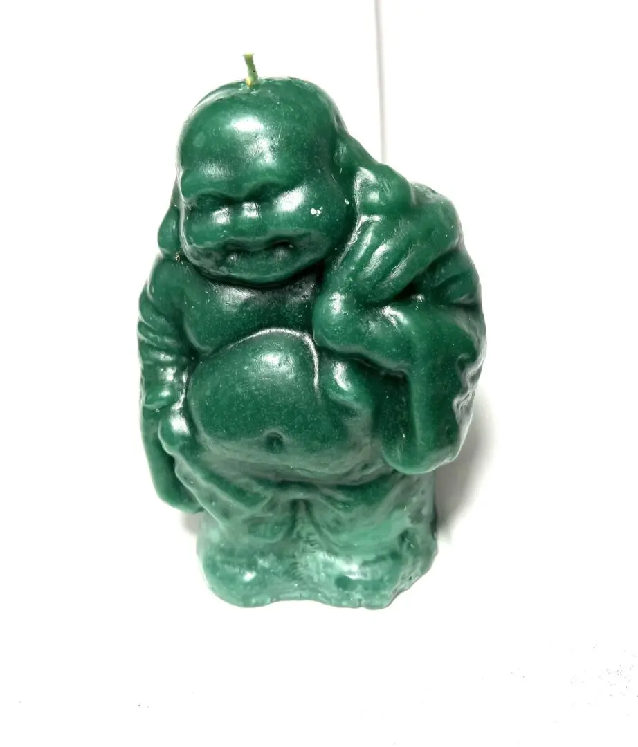 A green candle that is shaped like a buddha. A green candle that is shaped like a buddha.