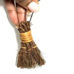 A person holding a small broom in their hand.