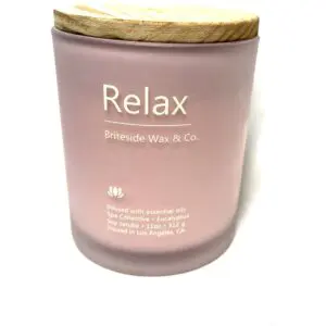 A candle that says relax on it.