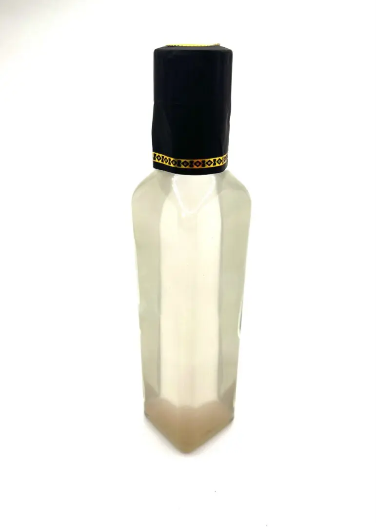 A bottle of lotion with black cap on top. A bottle of lotion with black cap on top.