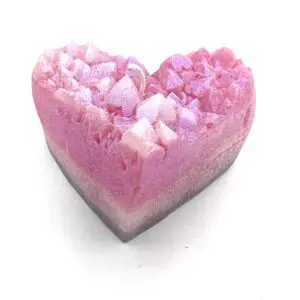 A pink heart shaped soap with white and purple sprinkles.