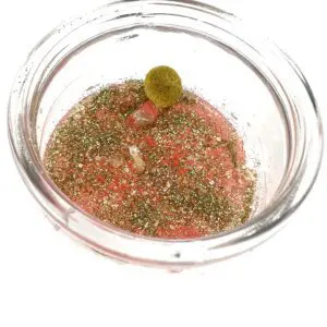 A bowl of food with a green olive in it.