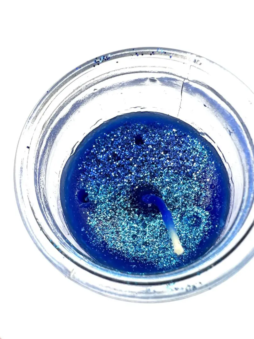 A glass of blue liquid with a stick in it. A glass of blue liquid with a stick in it.