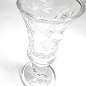 A glass cup with a flower design on it.