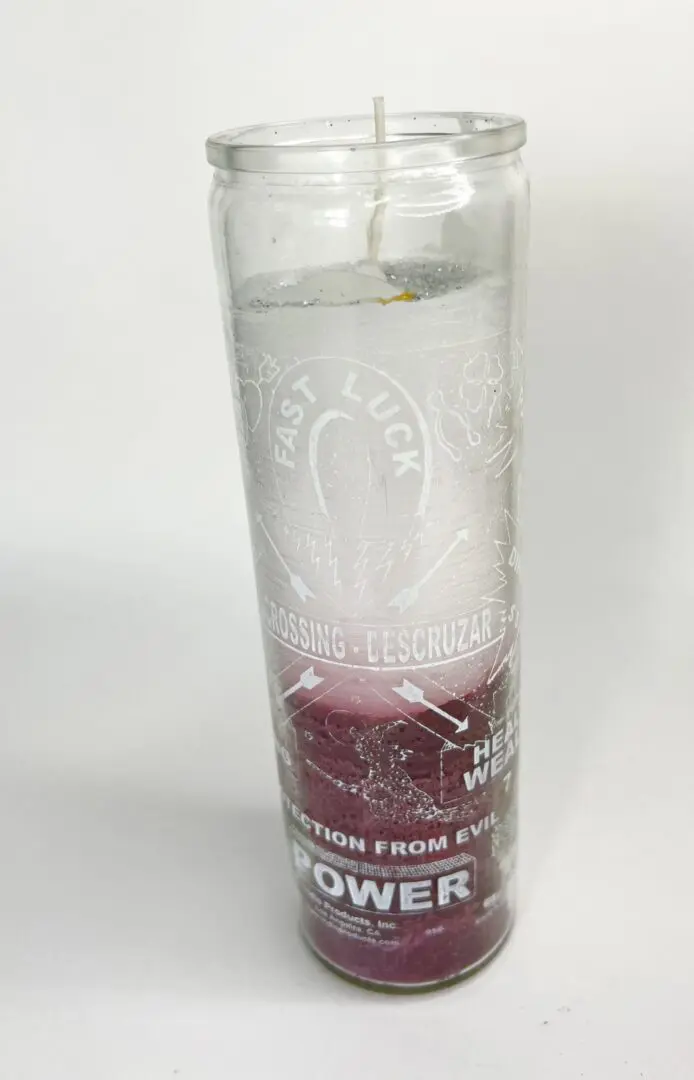 A candle that is sitting on the ground. A candle that is sitting on the ground.