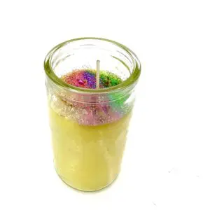 A candle in a glass jar with some wax.