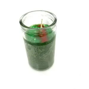A candle in a glass jar with green wax.