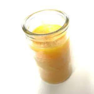 A jar of orange juice on top of a table.