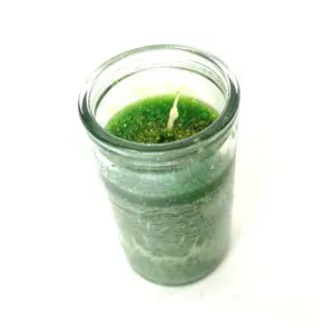 A candle in a jar with green moss on it.
