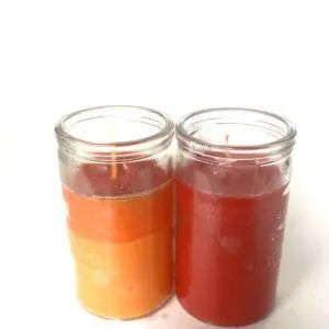 Two candles are sitting side by side on a table.