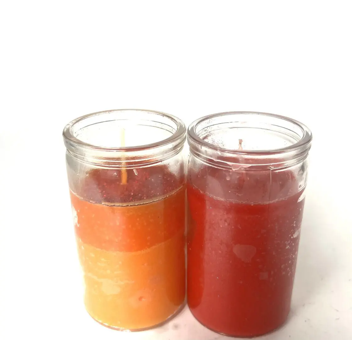 Two candles are sitting side by side on a table. Two candles are sitting side by side on a table.