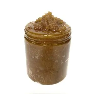 A jar of brown sugar on top of white background.
