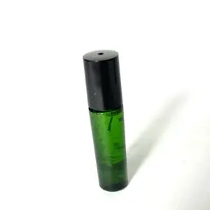 A green bottle with black cap on white surface.