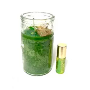 A candle and a roll of perfume sitting next to each other.