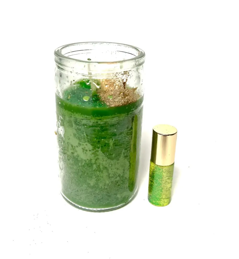 A candle and a roll of perfume sitting next to each other. A candle and a roll of perfume sitting next to each other.