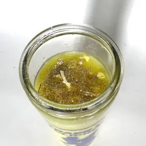 A candle in a glass is sitting on the table.