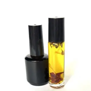 A bottle of oil and a container with some flowers.