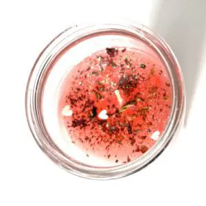 A glass of liquid with some red stuff in it