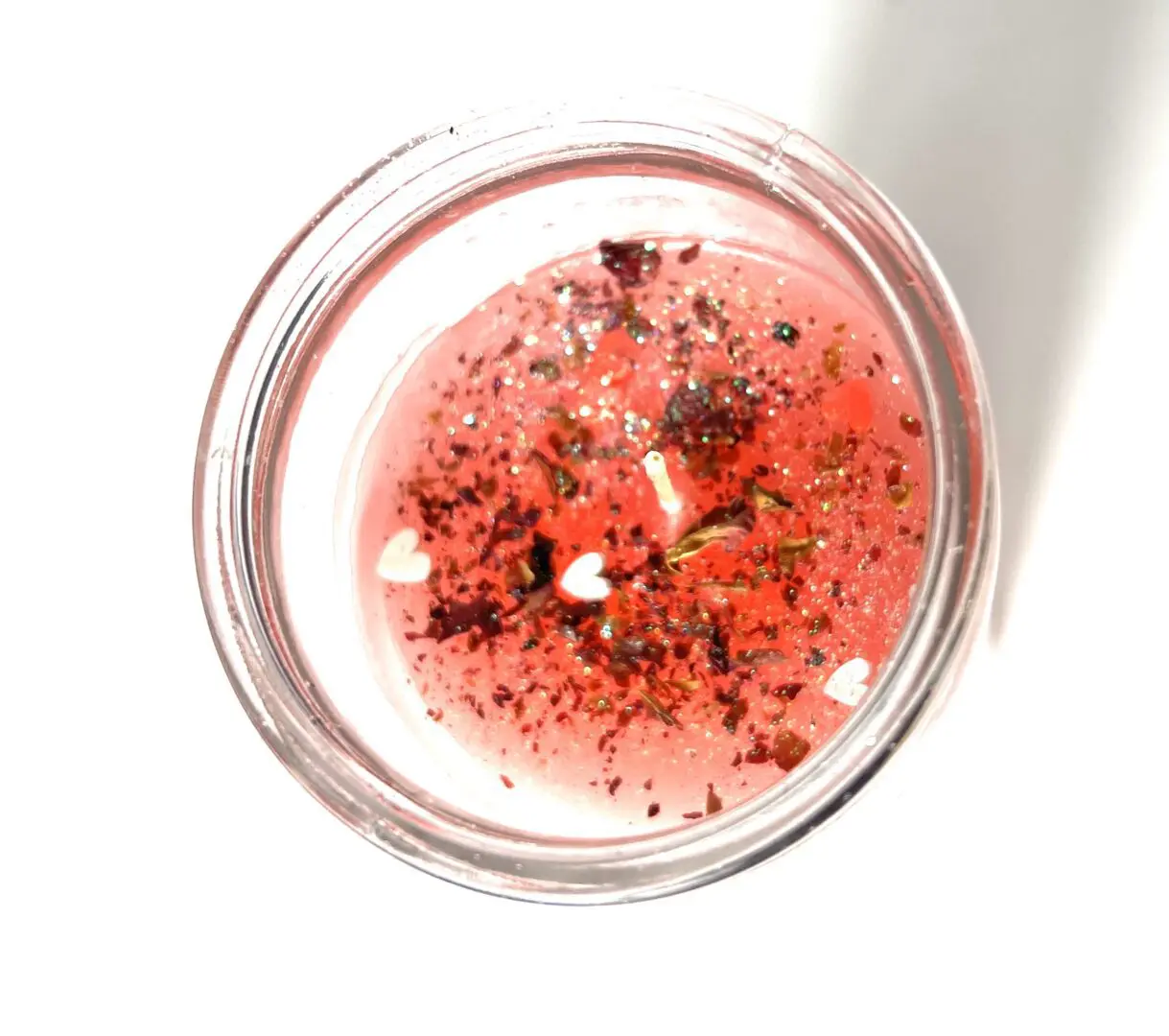 A glass of liquid with some red stuff in it A glass of liquid with some red stuff in it