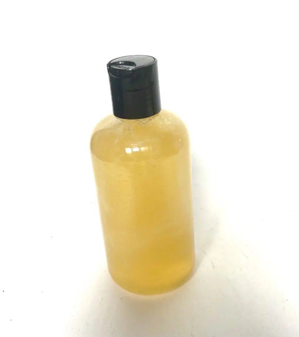 A bottle of liquid sitting on top of a table. A bottle of liquid sitting on top of a table.