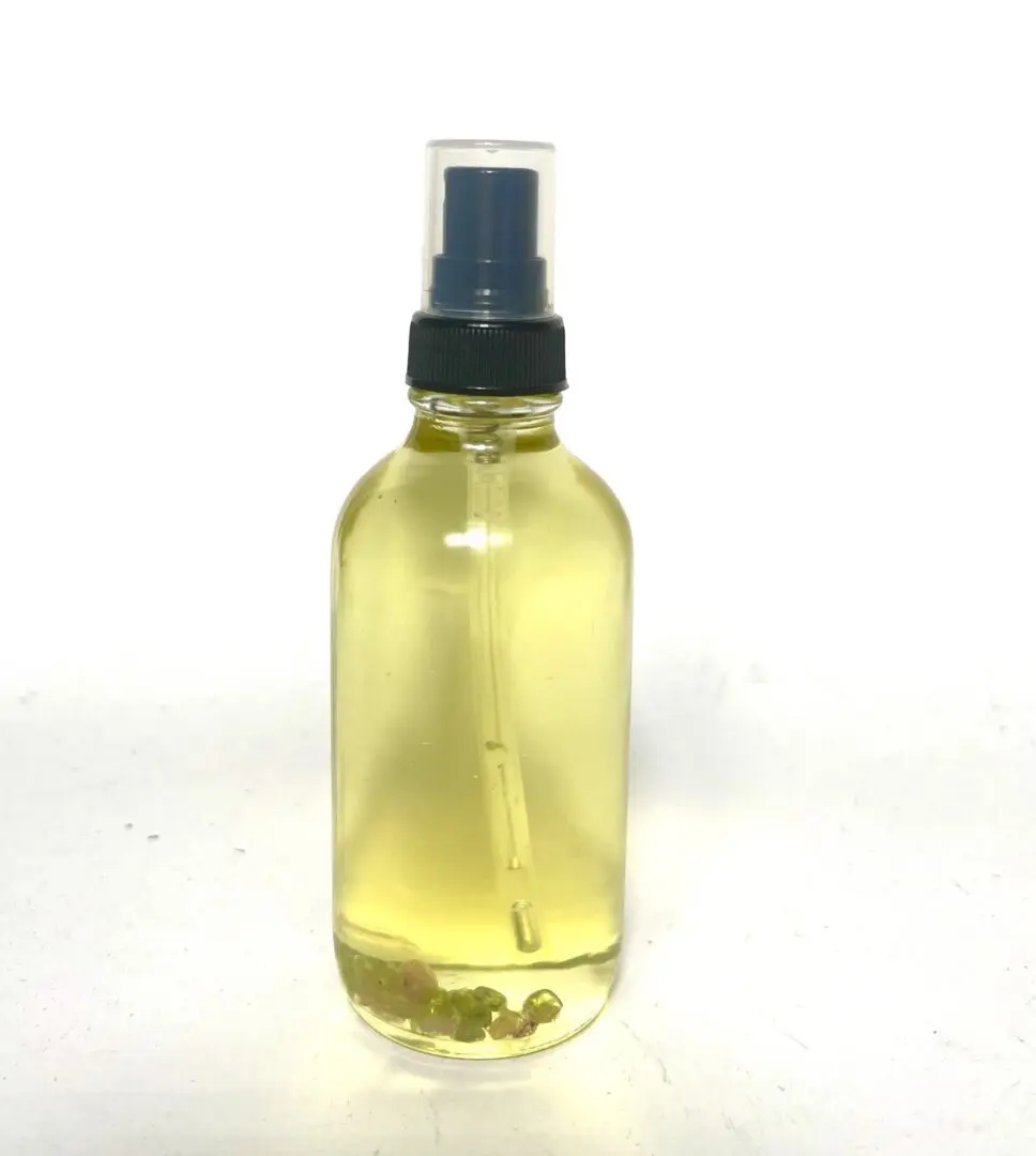 A bottle of oil sitting on top of a table. A bottle of oil sitting on top of a table.