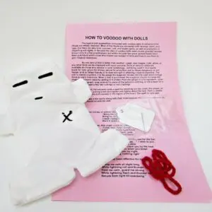 Pink voodoo doll with red yarn and needle.