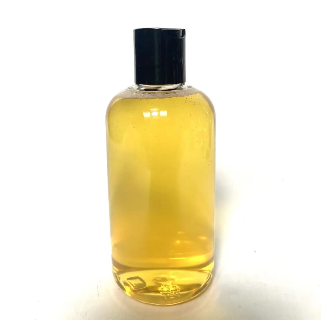 A clear bottle filled with yellow liquid and a black cap. A clear bottle filled with yellow liquid and a black cap.