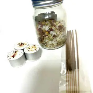 Sushi rolls, chopsticks, and a jar of dried ingredients on a white surface.