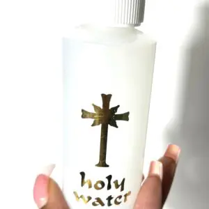 A white bottle labeled 'holy water' with a cross design.