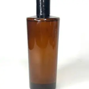 Tall amber glass bottle with black cap against white background.