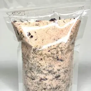 Transparent bag filled with a granular mixture of light and dark particles.