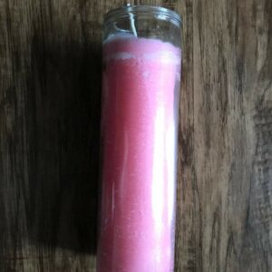 Pink glass jar candle on wood table.