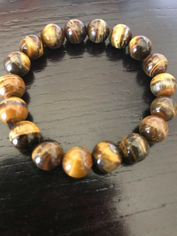 Tiger's eye bead bracelet on wooden surface.