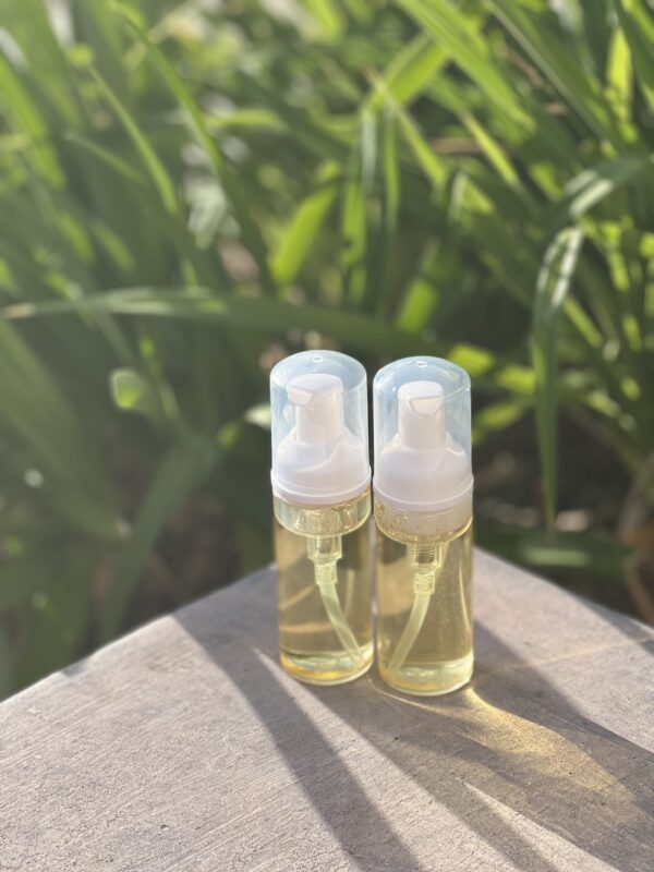 Two bottles of lotion sitting on a table.