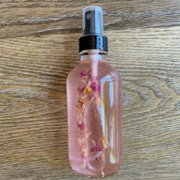 Pink liquid spray bottle with rose petals.