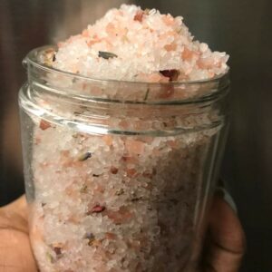 Pink Himalayan salt bath soak with flowers.