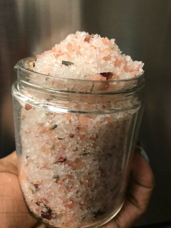 Pink Himalayan salt bath soak with flowers.