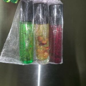 Three glitter roller bottles in a mesh bag.