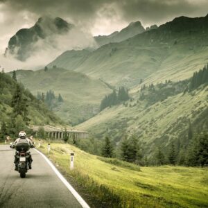 Motorcyclist drives through mountain pass.