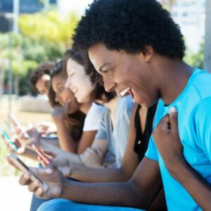 Man excited looking at phone with friends.