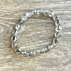 Clear quartz beaded bracelet with black inclusions.