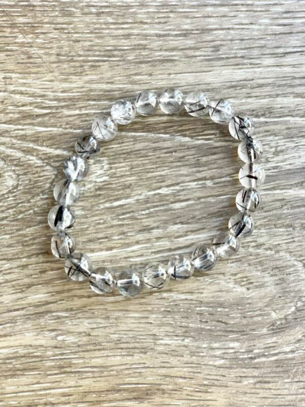 Clear quartz beaded bracelet with black inclusions.